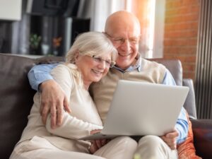 Senior couple browsing the internet together. Retirees using a laptop computer at home