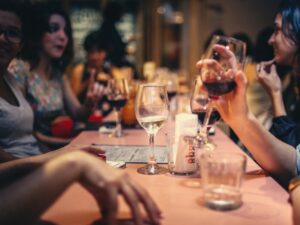 Diners at a restaurant table drinking wine