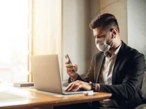 Traveller wearing face mask booking flight COVID-19