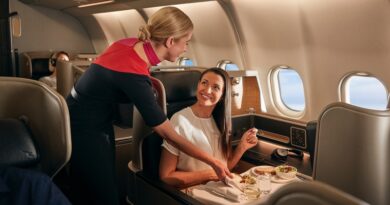 Inflight staff serving food to a female business passenger in the business cabin, Qantas A330