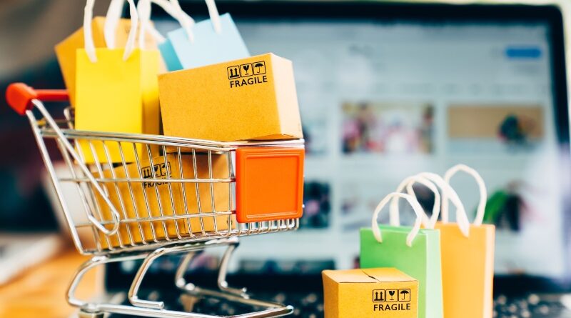 Product package boxes and shopping bag in cart with laptop computer which web store shop on screen for online shopping and delivery concept