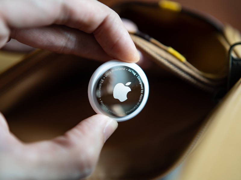 Apple Airtag being placed into checked luggage bag