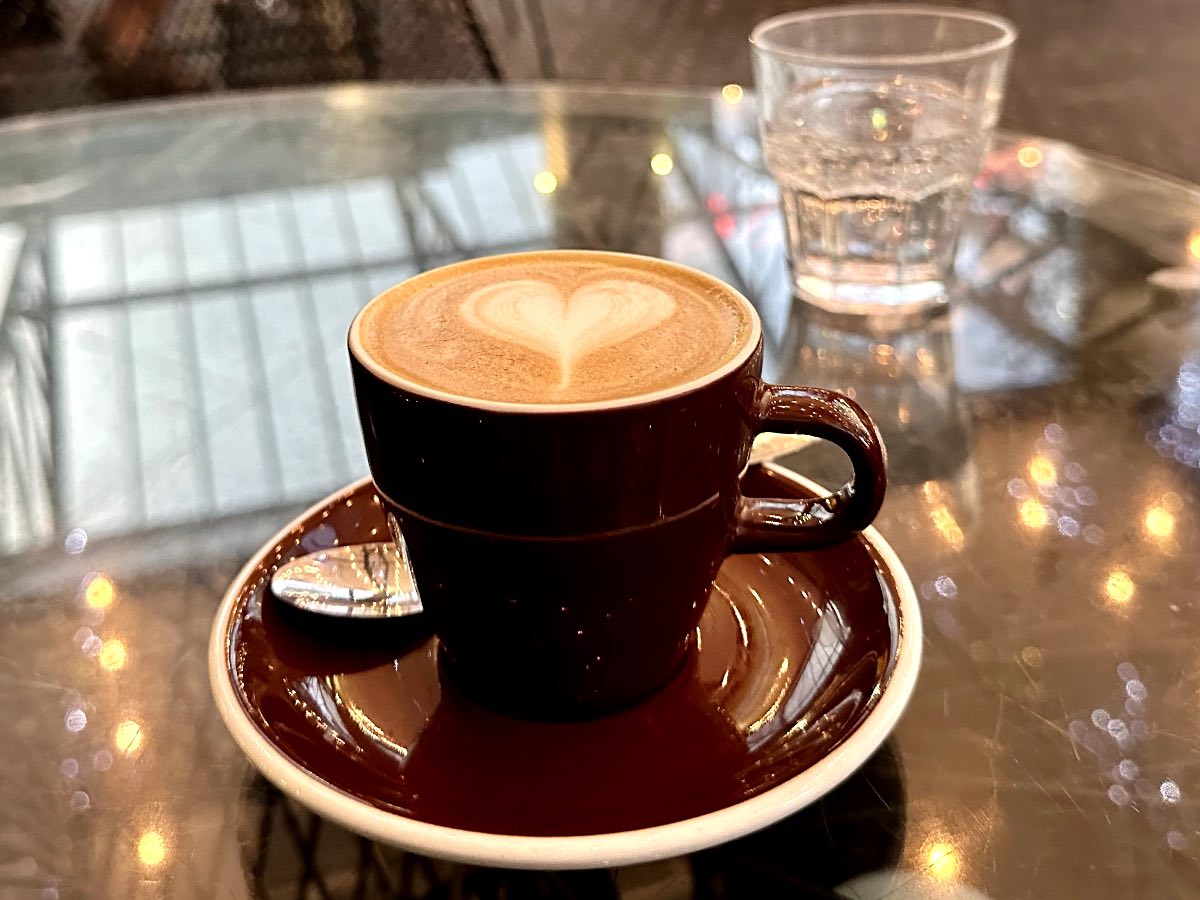 Flat white coffee in mug at cafe in Auckland