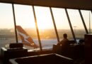 Man sitting in the Qantas First Lounge in Sydney with an Airbus A380 in the background