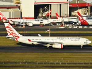 Virgin Australia A330 taxies past Qantas planes at Sydney Airport