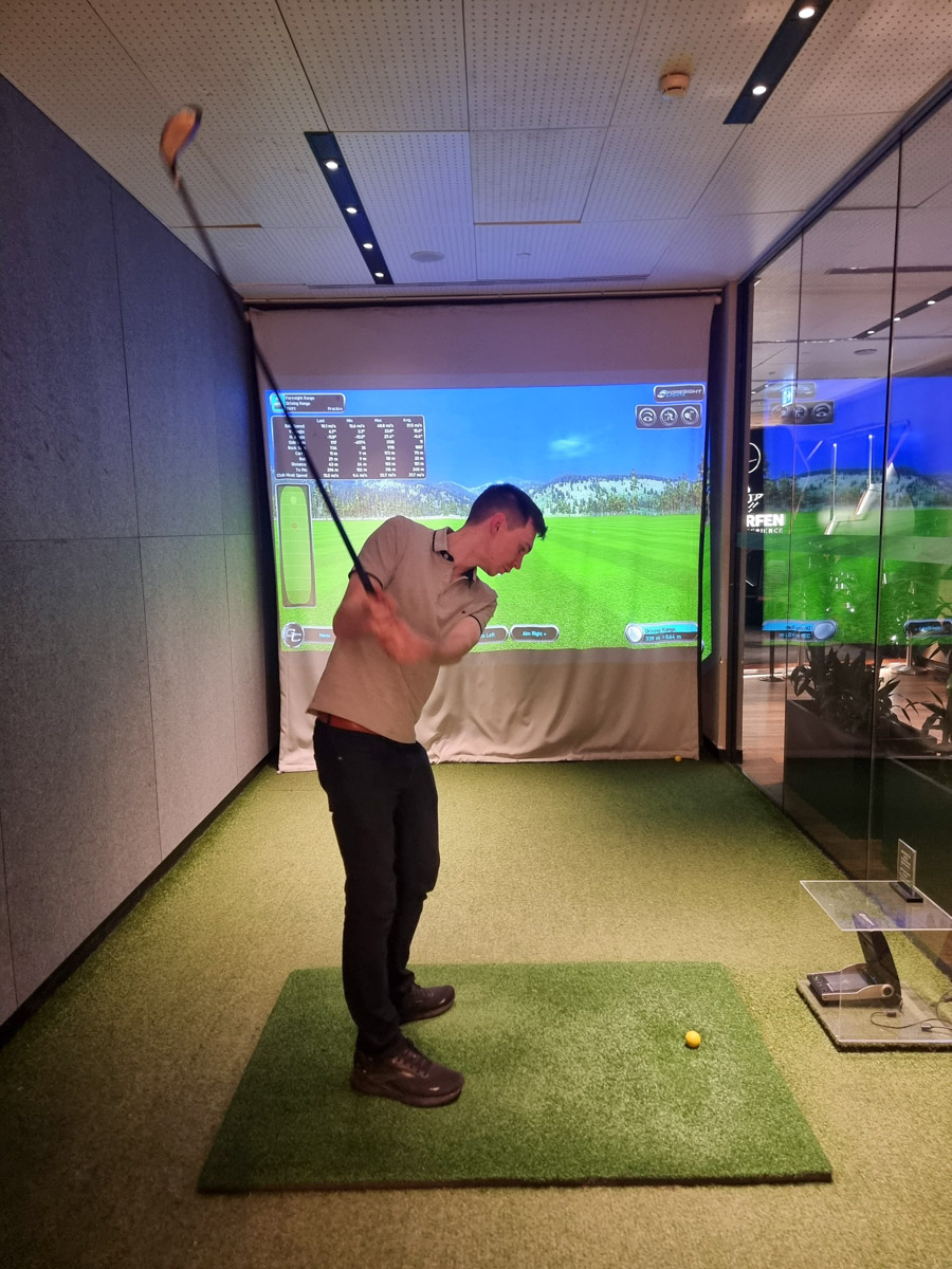 Matt Graham uses the golf simulator in the Turkish Airlines Business Lounge