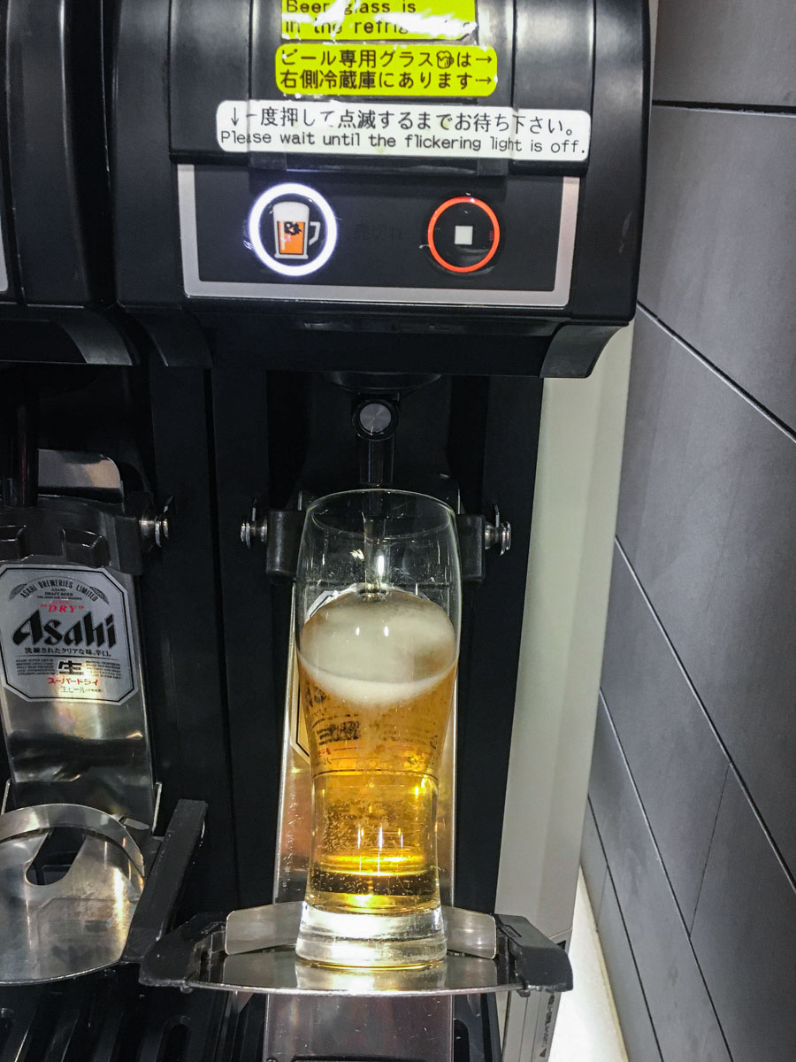 A self-pouring Asahi beer tap at a Japanese airport lounge