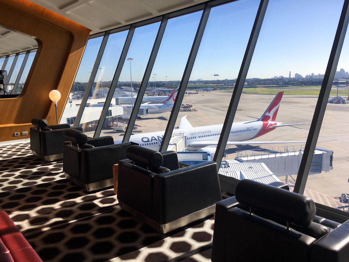 Window seats in the Qantas First Lounge at Sydney Airport with a Qantas 787 in background