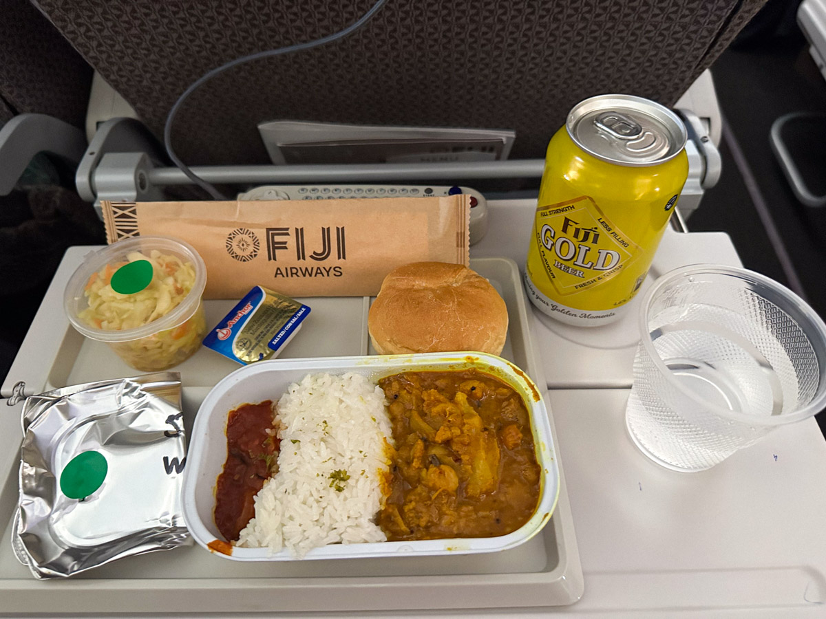 Roasted cauliflower, chickpea & coconut curry with steamed jasmine rice & tomato chutney, the vegetarian meal option in Fiji Airways economy class with a Fiji Gold beer