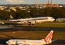 A Singapore Airlines A350 lands at Sydney Airport on runway 25 with a Virgin Australia 737 in foreground