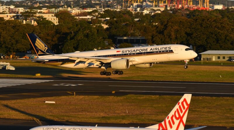 A Singapore Airlines A350 lands at Sydney Airport on runway 25 with a Virgin Australia 737 in foreground