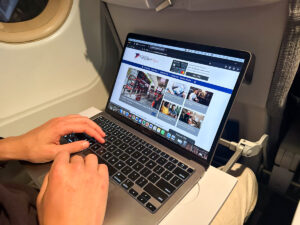 Browsing the Australian Frequent Flyer (AFF) website on a laptop while on a plane