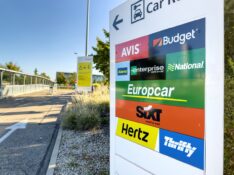 View of multiple rental cars Avis, Budget, Alamo, Enterprise, national, Europcar, Sixt, Hertz, Thrifty in the parking of large international Airport