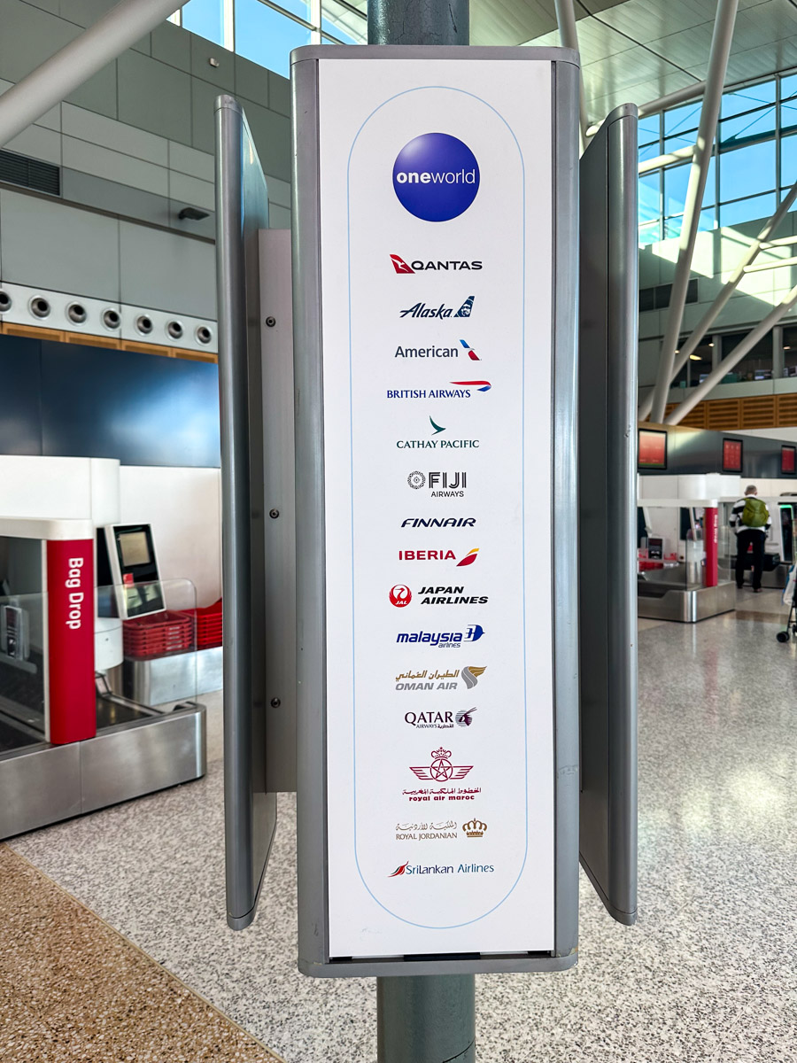 Sign at Sydney Airport Terminal 3 listing all the Oneworld alliance airlines