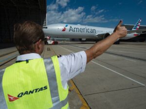 Qantas crew giving thumbs up to an American Airlines Boeing 777-300ER
