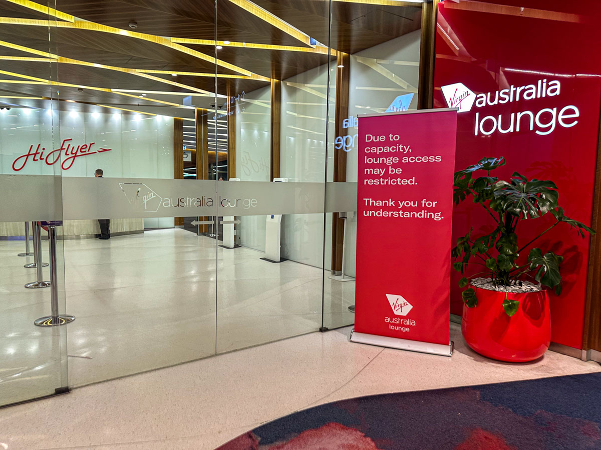 The Virgin Australia Lounge at Melbourne Airport with a capacity restriction sign