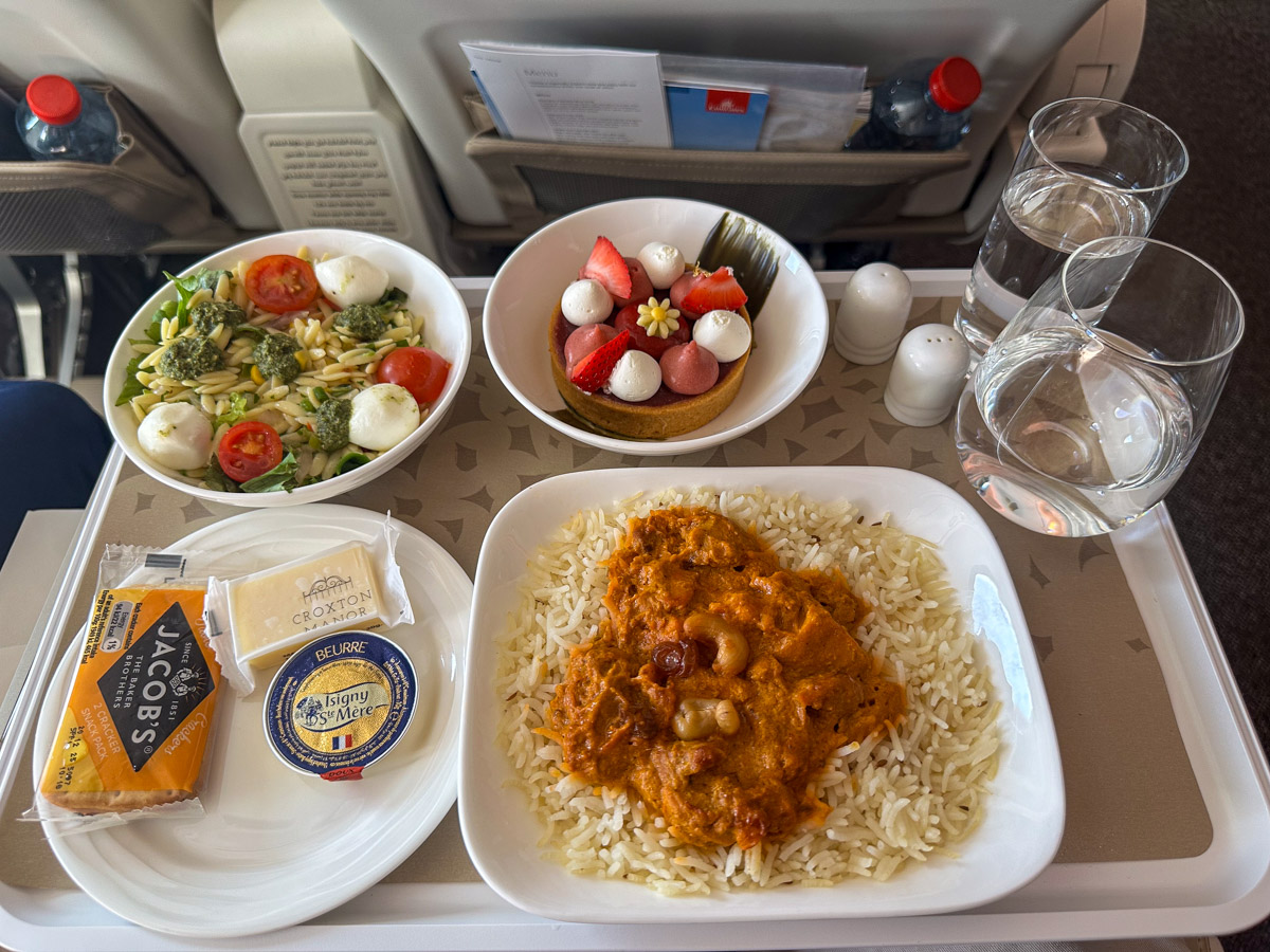 Emirates premium economy meal of butter chicken with jeera pulao, garnished with cashew nuts and raisins