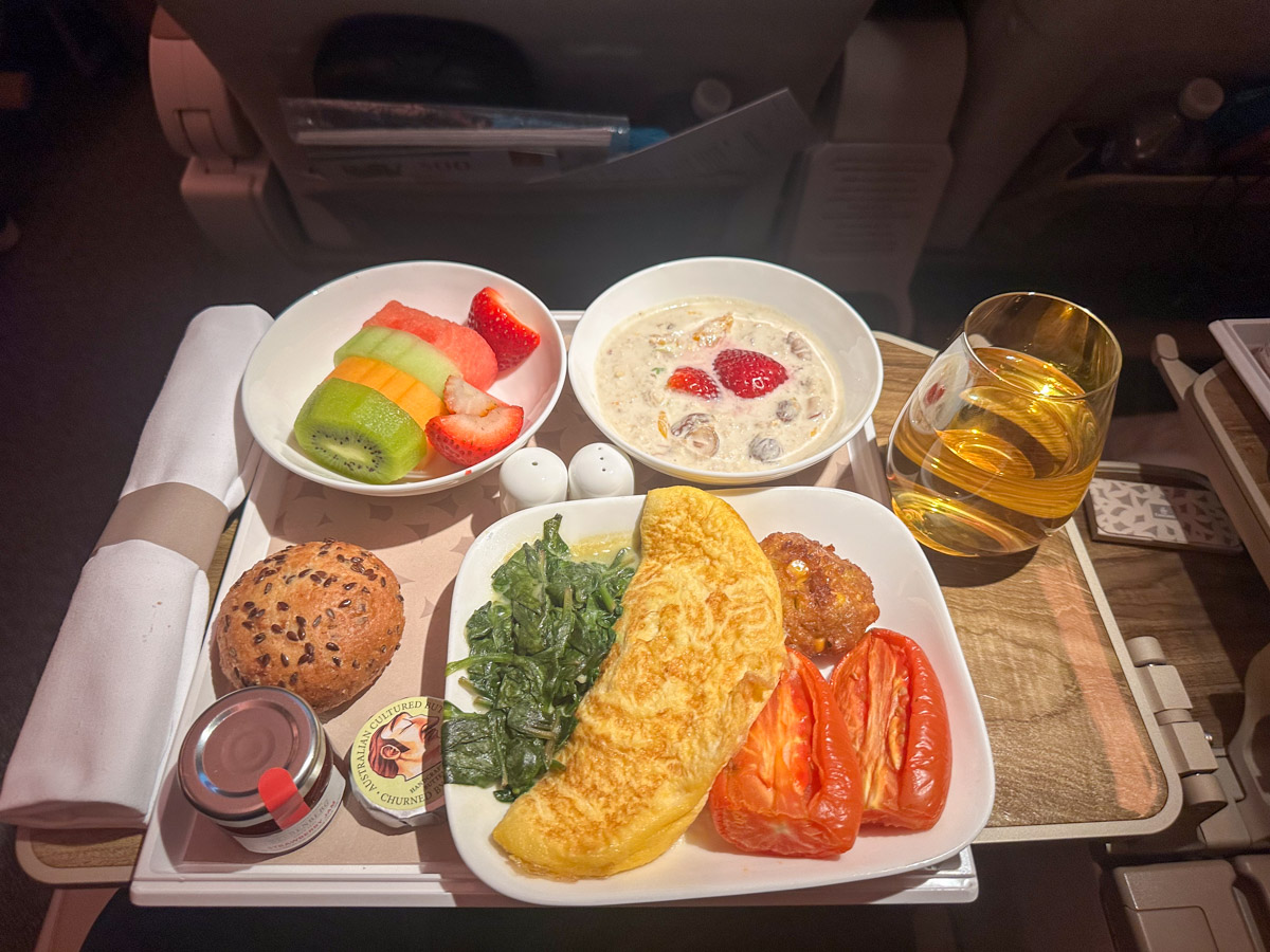 Mushroom omelette with sweetcorn cake, creamed spinach and roasted tomato, served with seasonal fruit and Bircher muesli for breakfast on an Emirates flight