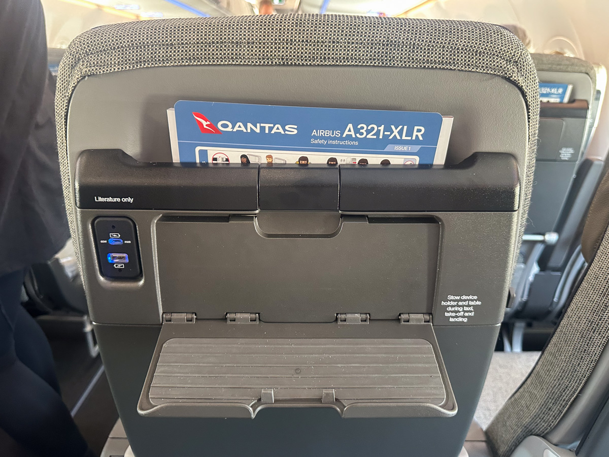 Seatback with device holder and charging outlets on the Qantas A321XLR.