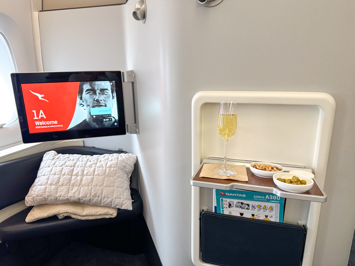 Pre-departure champagne, nuts and olives in Qantas First Class seat 1A