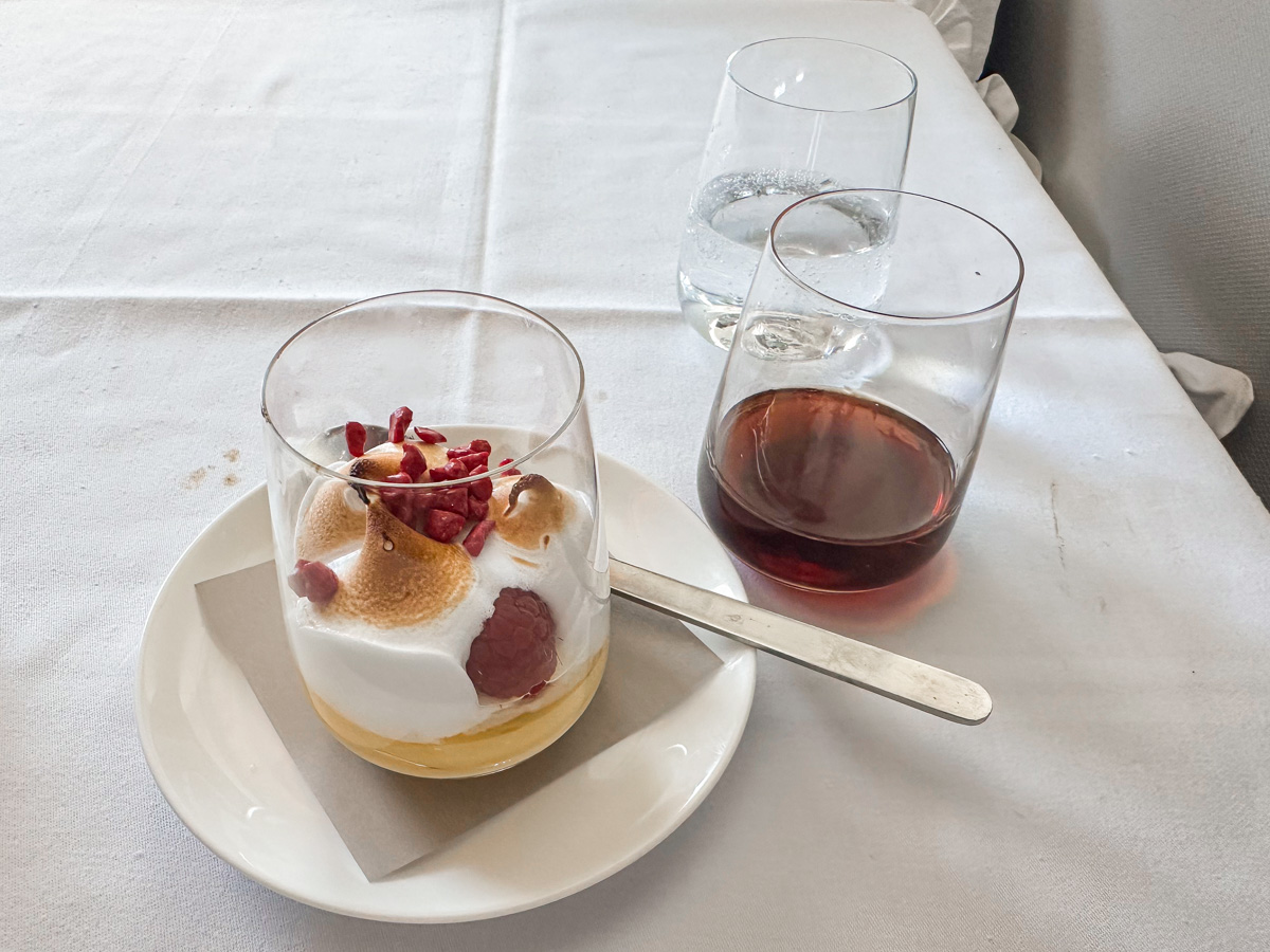 Three milk cake with jasmine tea, passionfruit curd, raspberry and meringue for dessert in Qantas first class, served with a dessert wine