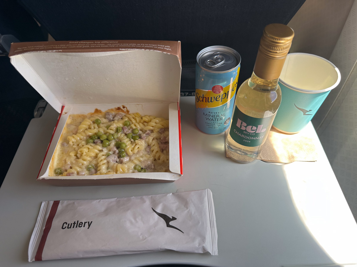 Qantas hot boxed lunch meal of pasta carbonara with drinks including wine