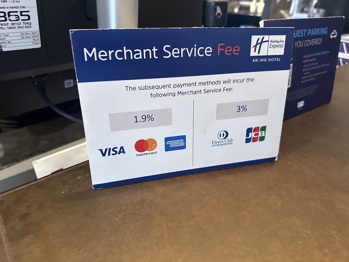 Card card surcharge sign on the counter of a hotel desk advising of merchant service fees