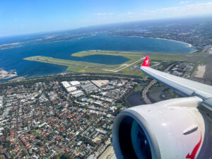 QantasLink A220 takes off from Sydney Airport, view of wing out the window