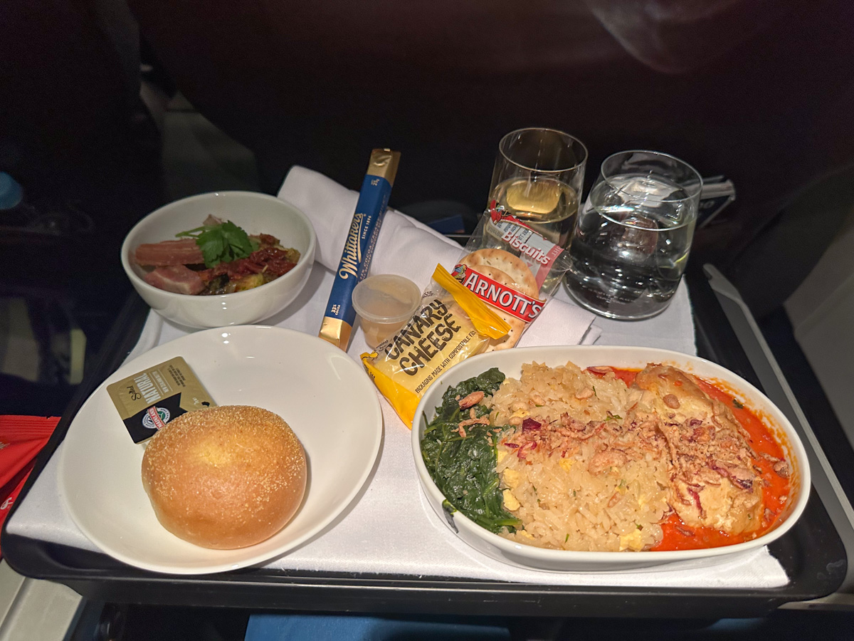 Chicken with fried rice and a bread roll served in Qantas business class