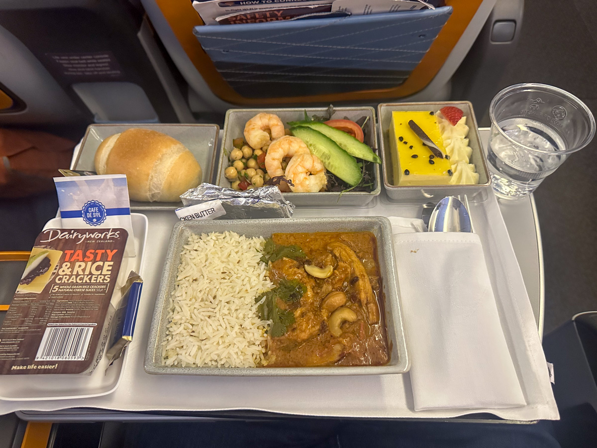 Butter chicken with a chickpea and vegetables salad and passionfruit cheesecake served in Singapore Airlines premium economy class