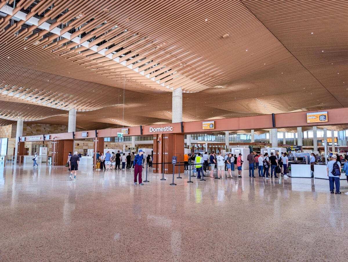 Passengers queuing at domestic security beneath the rippling timber-batten ceiling of the WSI departures hall