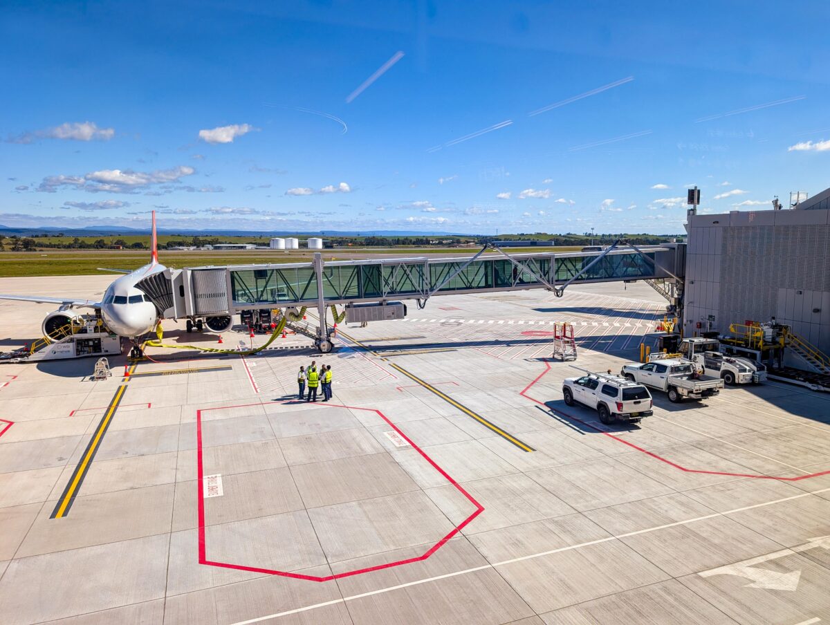 Jetstar Airbus A320neo at an aerobridge with ground crew and a tug on the WSI apron