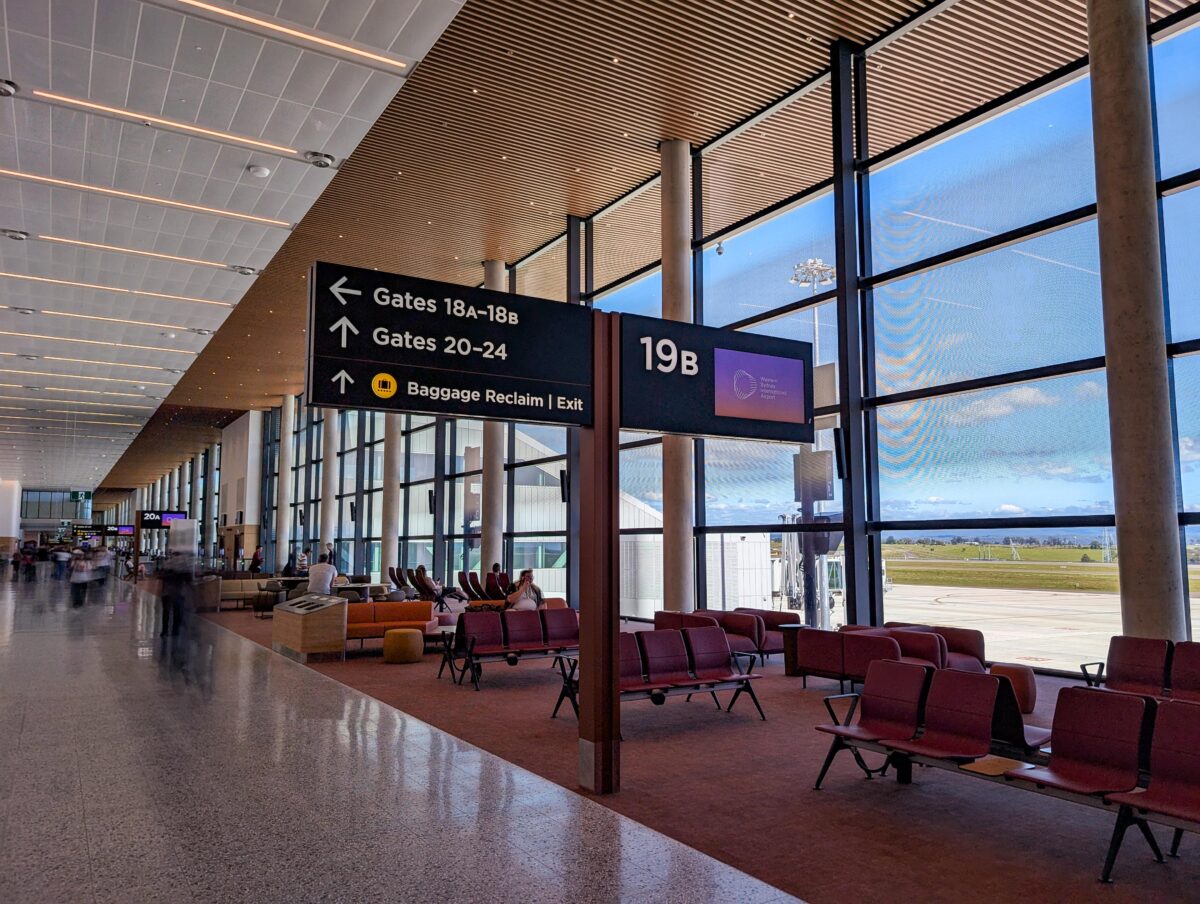 Airside seating and signage for gates 18A-18B and 20-24 next to floor-to-ceiling windows at WSI