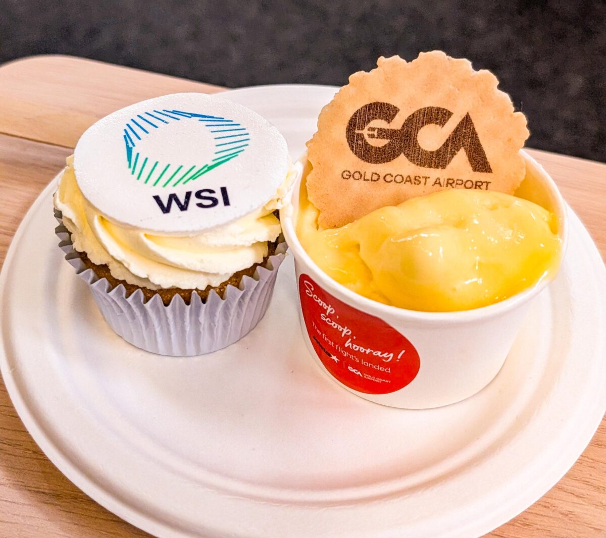 WSI-branded cupcake and a Gold Coast Airport ice cream cup on a plate